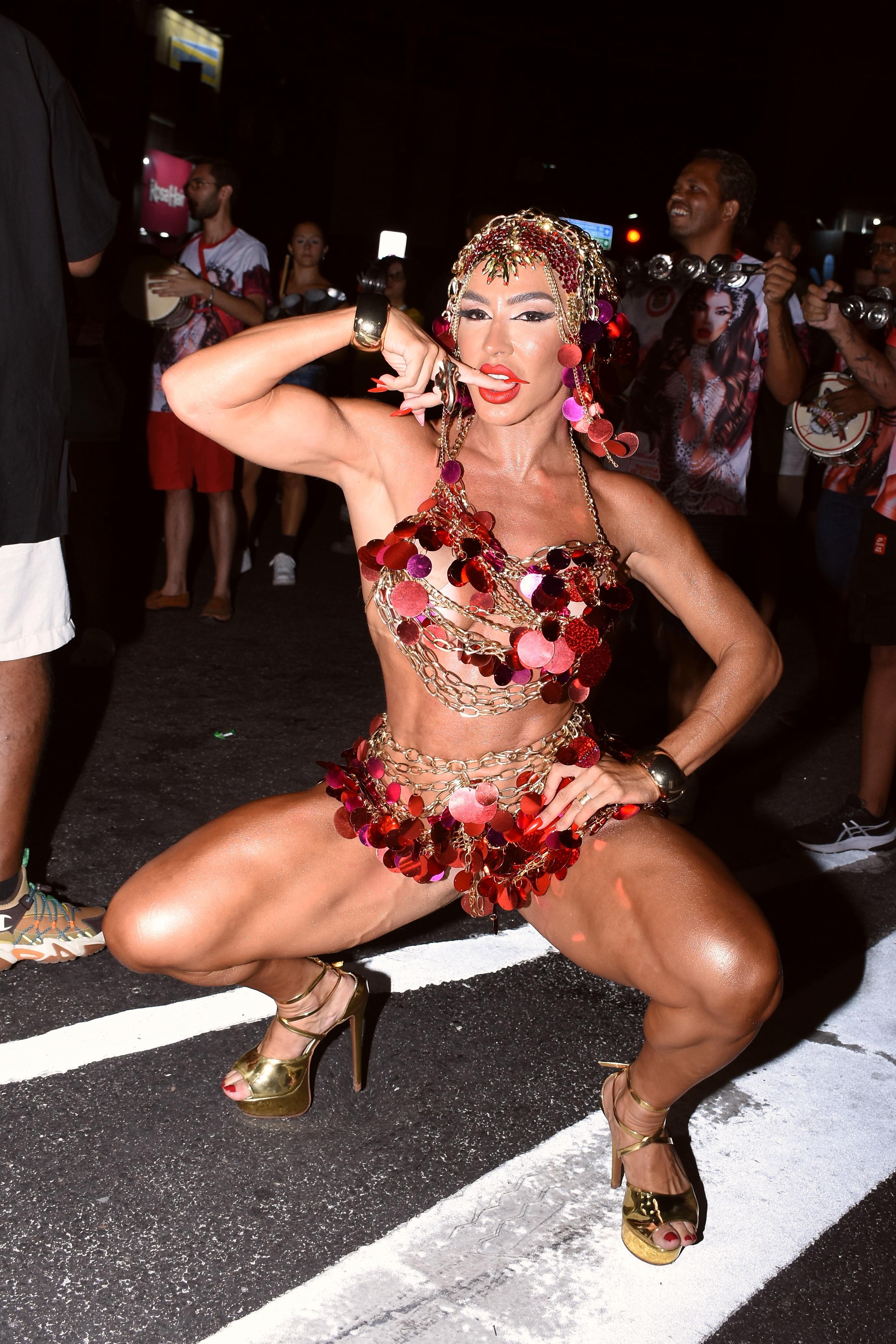 Andréa de Andrade, a musa das supercoxas, usa fantasia com correntes e paetês à frente da bateria