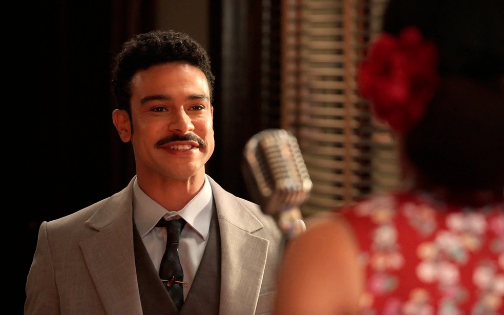 Lourival Piseli (Sérgio Malheiros) elogia voz de Dita (Jeniffer Nascimento) em Êta Mundo Melhor! — Foto: Globo