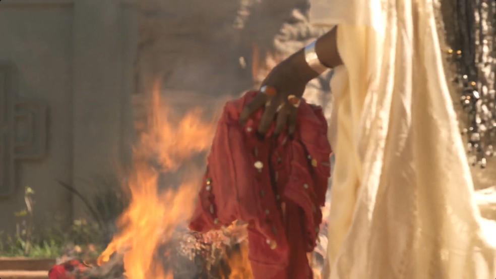 Binta irá queimar as roupas que pertenciam a Alika — Foto: Reprodução/TV Globo