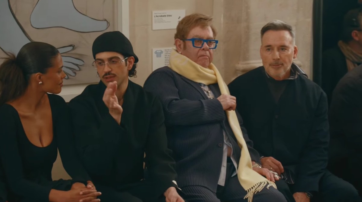 Elton John faz rara aparição pública ao lado do marido durante desfile de moda em Paris