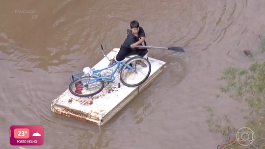 Menino transforma porta em canoa para resgatar bicicleta nas enchentes que atingem o RS