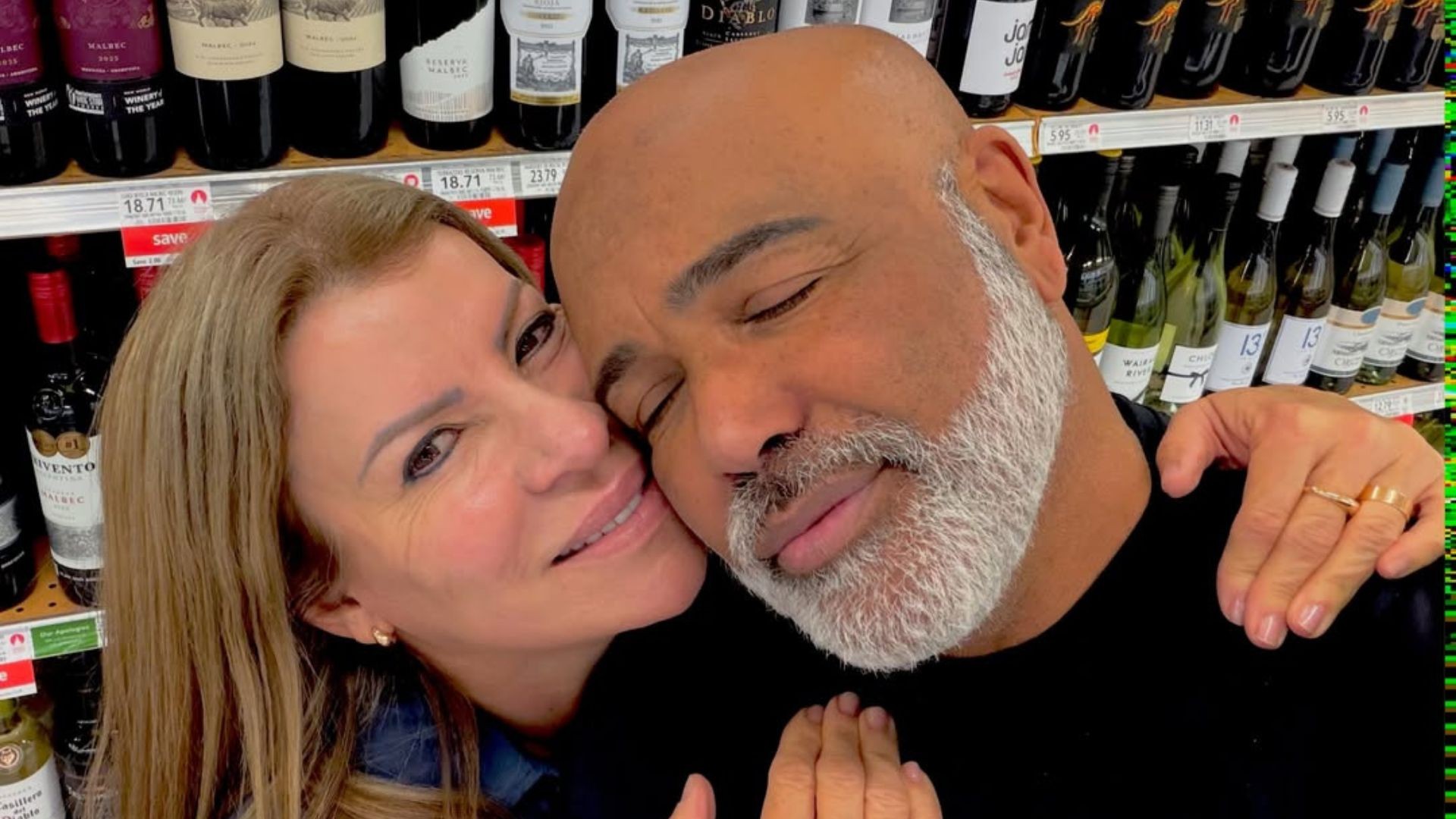 Foto do casal Rick e Geralda sorrindo diante de rosas cor-de-rosa
