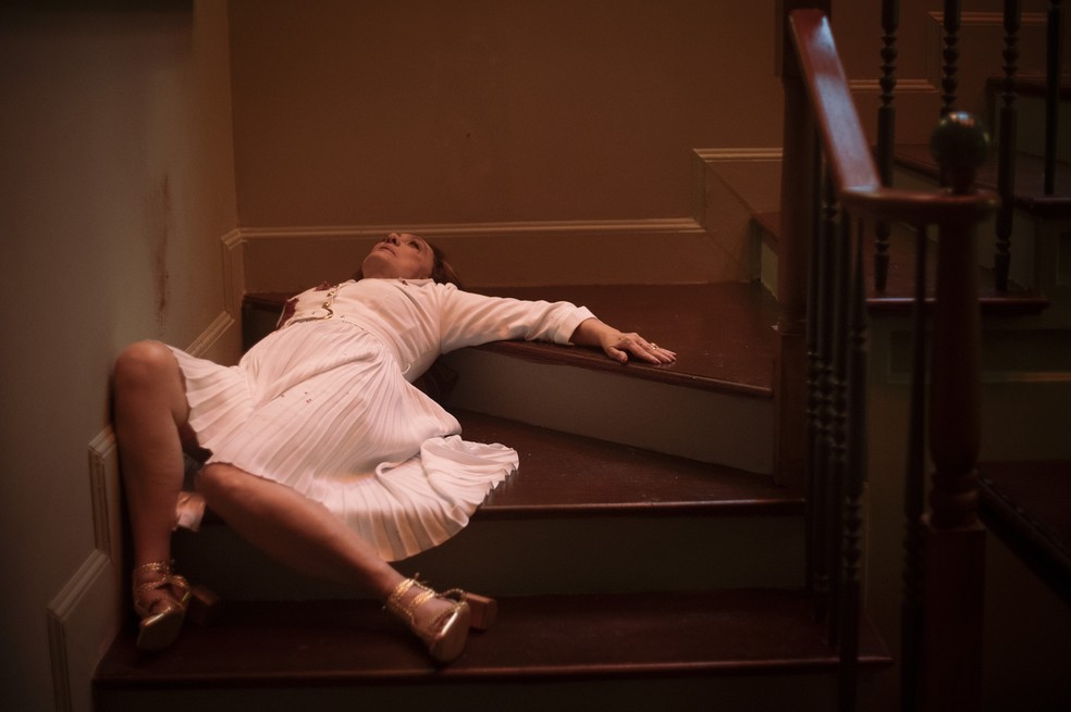 Agatha (Eliane Giardini) será encontrada caída na beira da escada com três tiros no peito — Foto: Gshow/Rapha Dias
