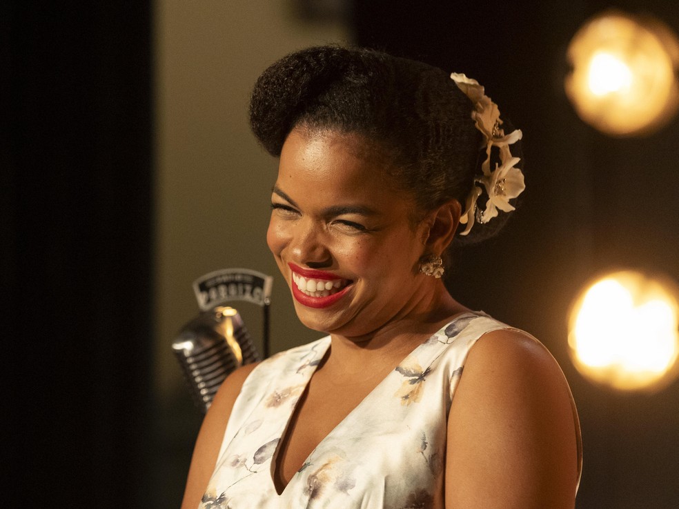 Candinho (Sergio Guizé) entrega a coroa de rainha da rádio para Dita (Jeniffer Nascimento), e se declara para a amada em Êta Mundo Melhor! — Foto: Globo/Léo Rosario