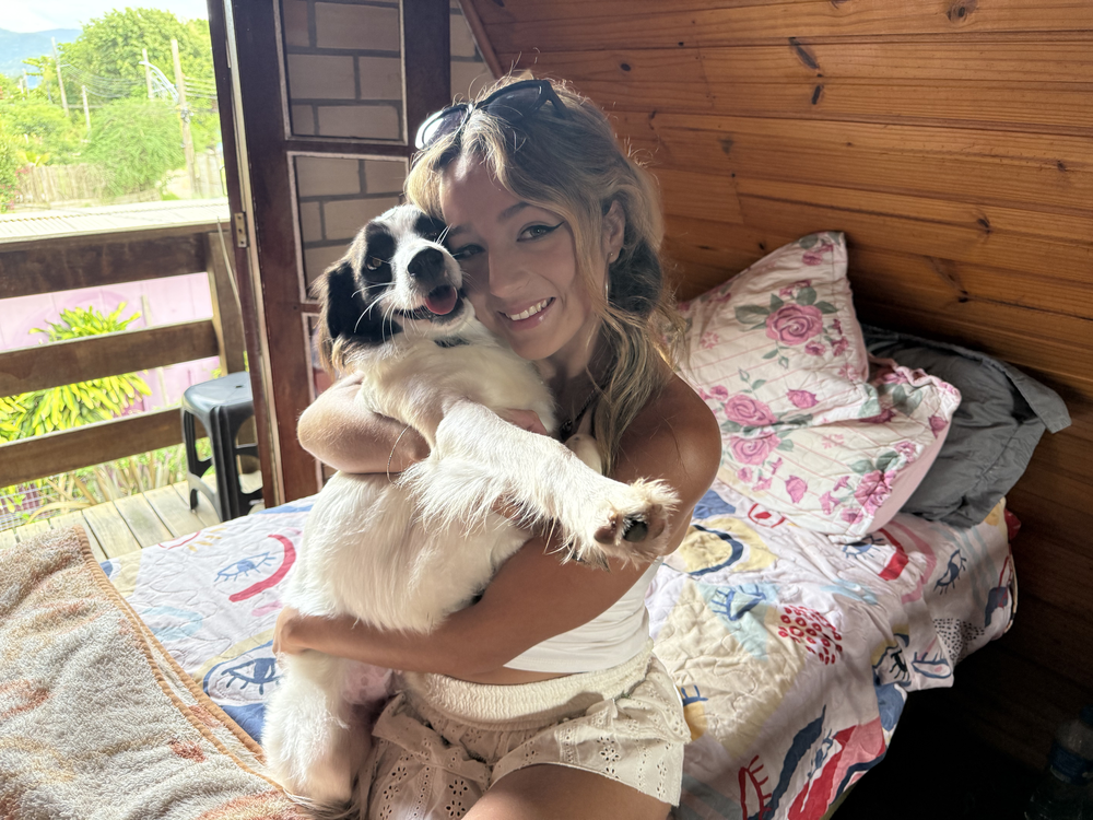 Samira e Lindolfo — cachorro de três patas que ela cuida na Praia do Rosa. BBB 26.