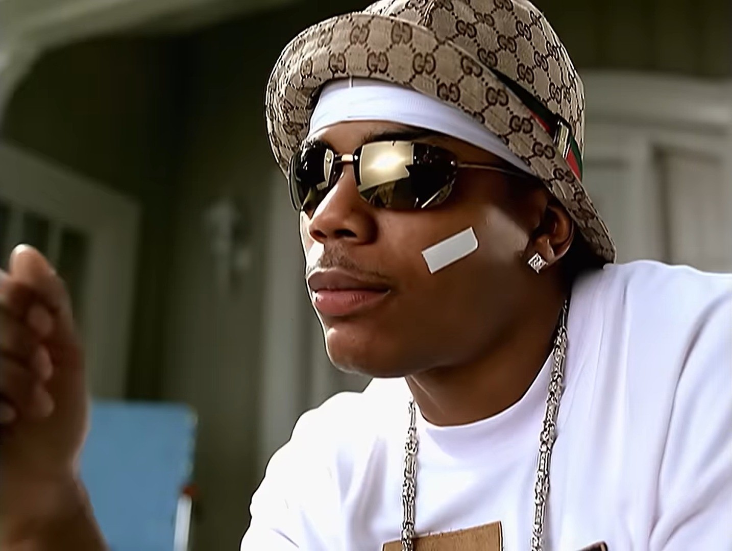 Nelly usando esparadrapo no rosto durante uma apresentação