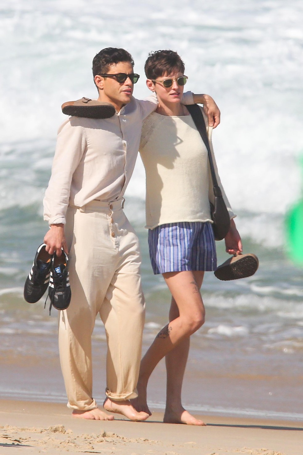 Emma Corrin e Rami Malek caminham na praia de Ipanema — Foto: Agnews
