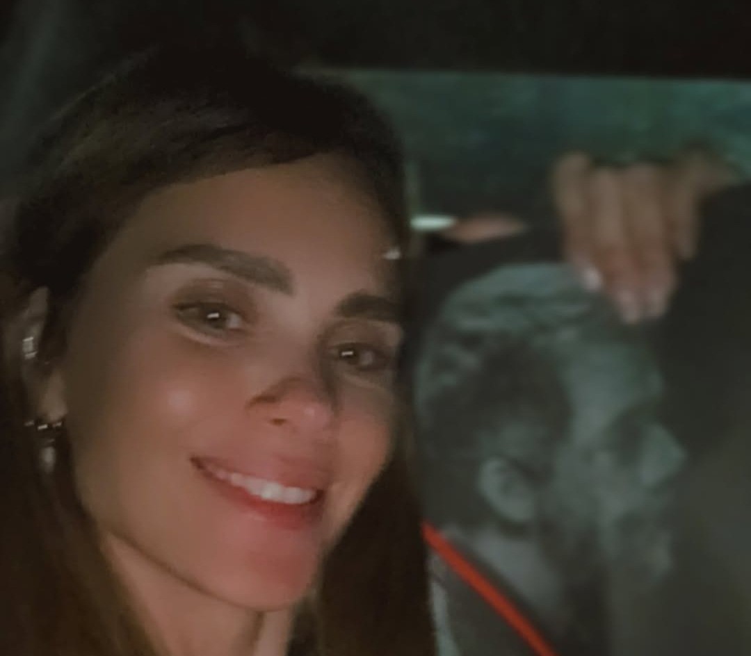 Carolina Dieckmmann posta selfie com cartaz de Wagner Moura: 'Não tive coragem de pedir foto'