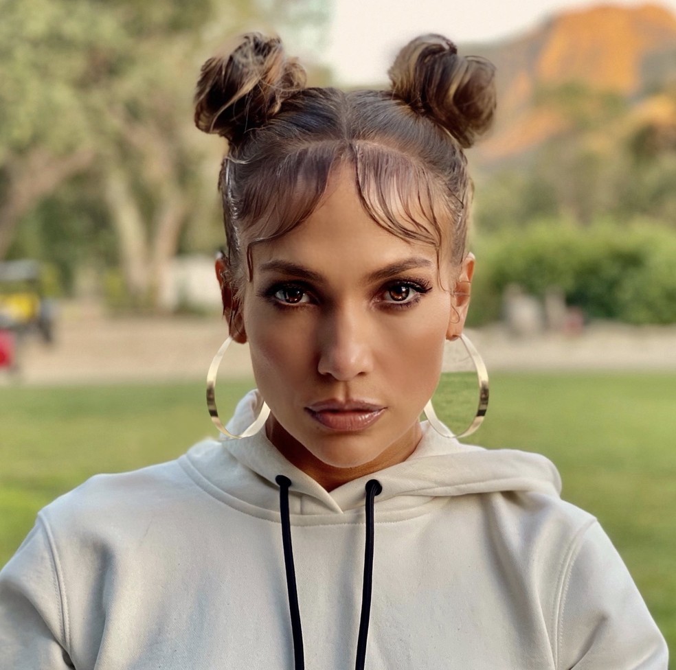 Jennifer Lopez apostou no coque duplo com o baby hair dividido ao meio, estilo curtain bangs — Foto: Reprodução/Twitter