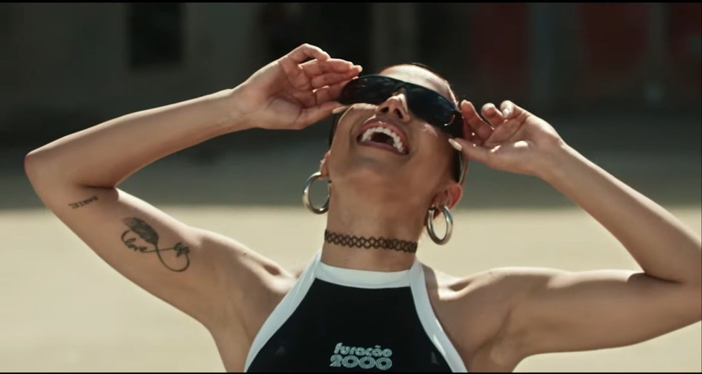Anitta usa top estampado com marca da Furacão 2000 em novo clipe — Foto: Reprodução/YouTube