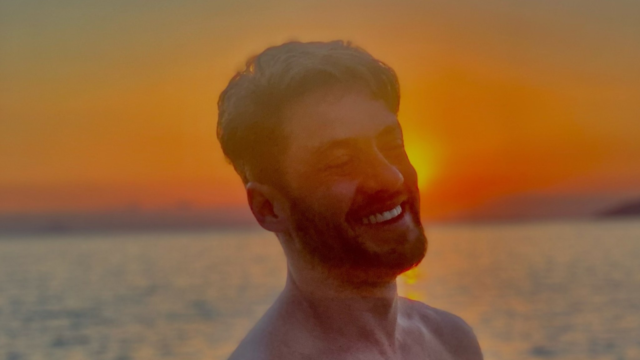 Leonardo Miggiorin posa de sunga branca no mar para celebrar o verão